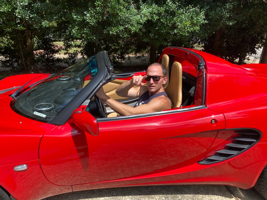 Kevin in a red convertible sports car