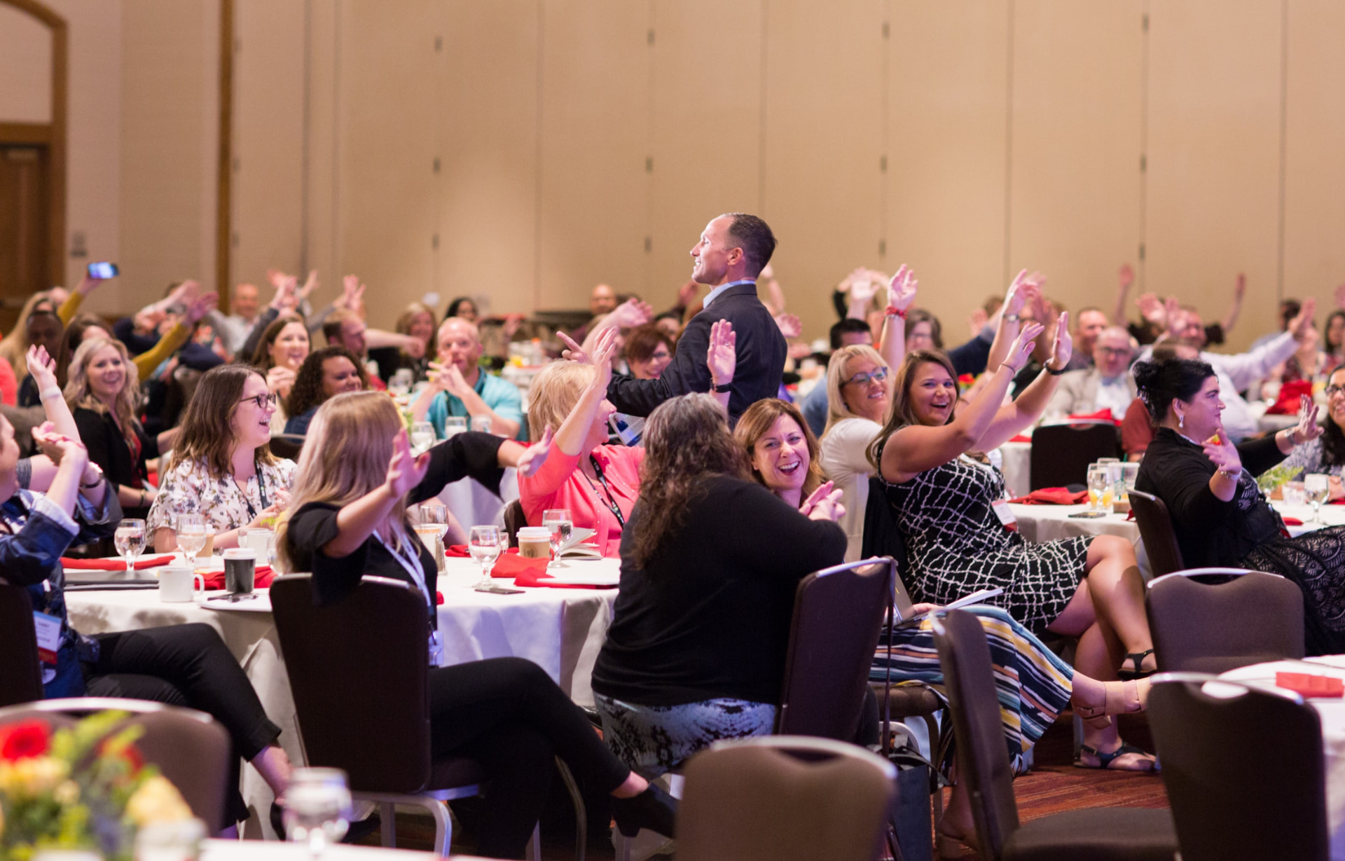 Audience with hands raised at a Kevin Snyder keynote