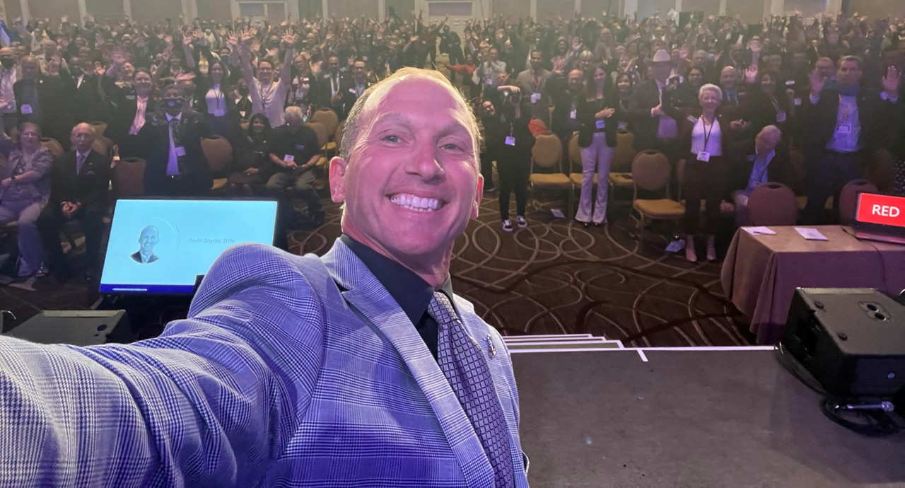 Kevin taking a selfie with a packed conference audience