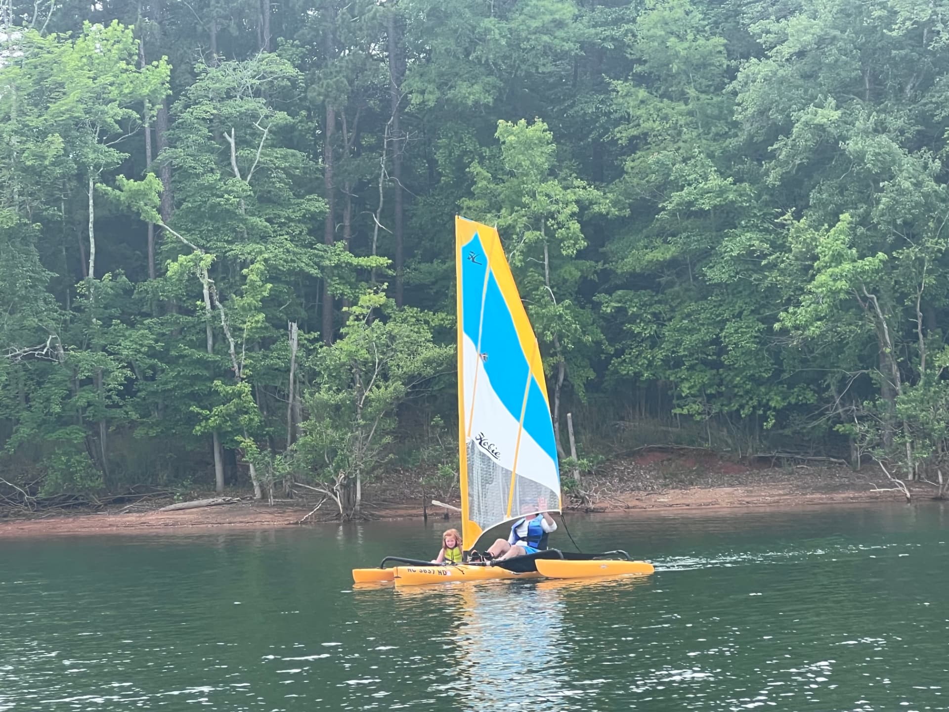Kevin sailing a small catamaran with his daughter